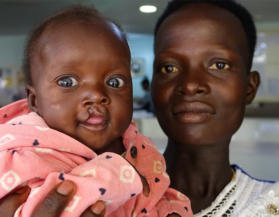 home-mission Mother holding baby in a pink shirt